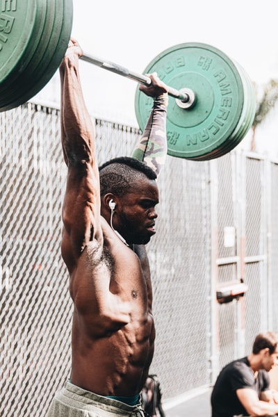 Handheld green dumbbell topless man
